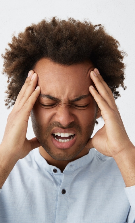 Stressed mixed race man with head of curly hair frowning his face holding hands on head having depression not knowing what to do suffering from headache having some serious problems in his life